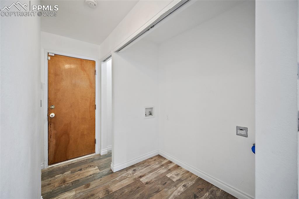 Image 25 of 50: Washroom with wood finished floors and hookup for a washing machine
