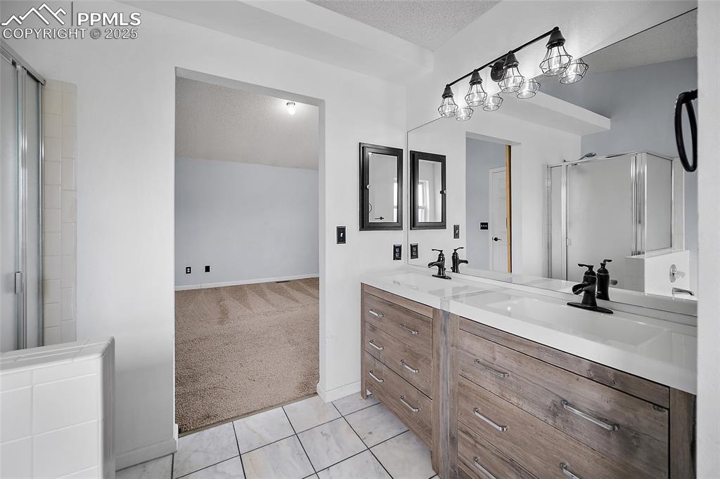 Image 34 of 50: Bathroom featuring light colored carpet, a shower stall, light tile pattern