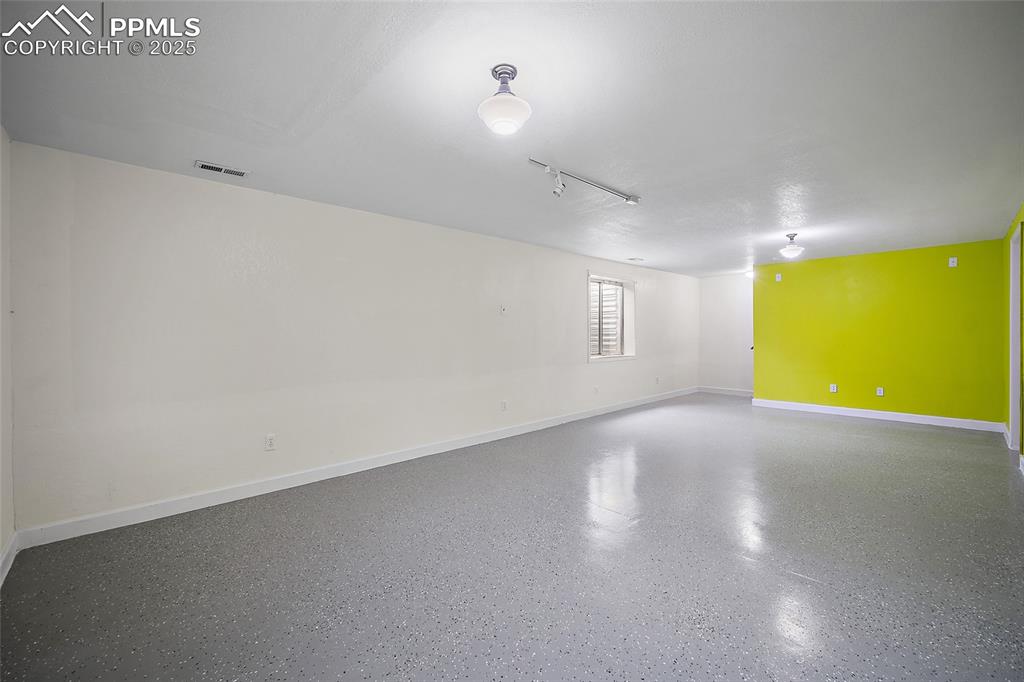 Image 42 of 50: Unfurnished room featuring baseboards and rail lighting