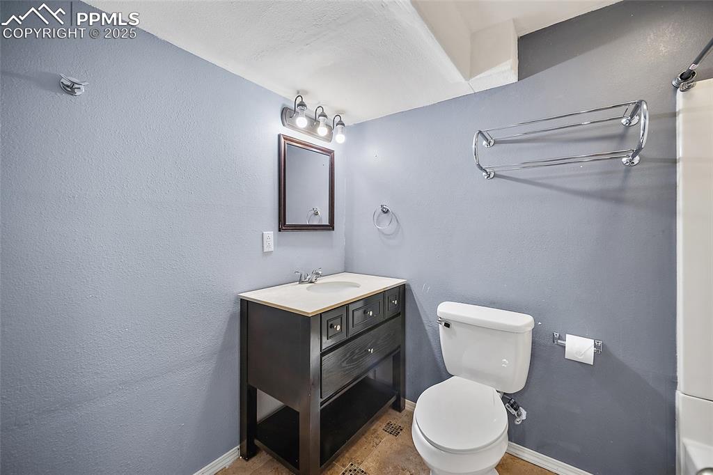 Image 43 of 50: Bathroom featuring vanity, a textured wall, and light tile patterned floors