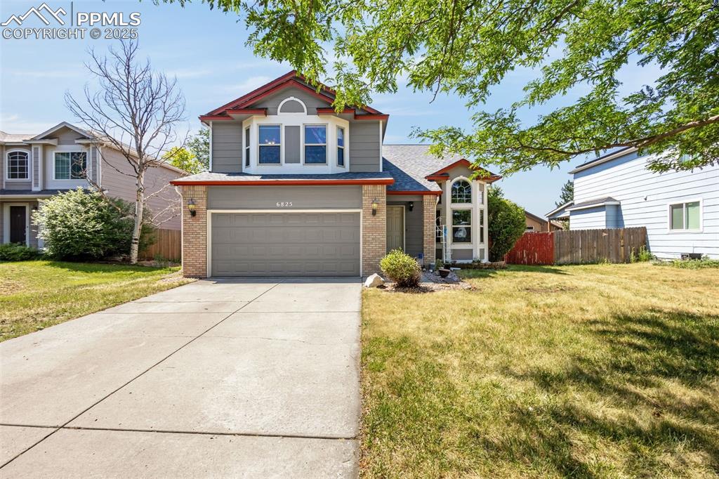 Caption: Traditional-style house featuring concrete driveway, brick siding, and a garage