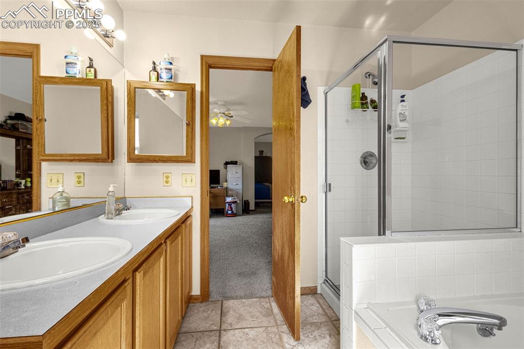 Image 14 of 33: Full bath with a ceiling fan, a stall shower, double vanity, a garden tub, 