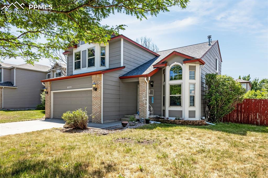 Image 2 of 33: View of front of home with brick siding, concrete driveway, a garage, and a