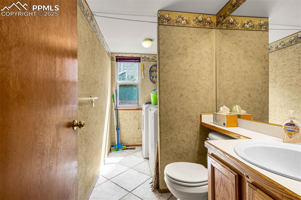 Image 24 of 33: Bathroom with vanity and tile patterned flooring