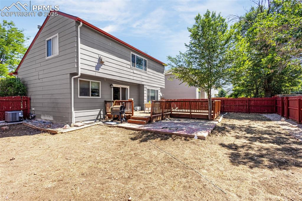 Image 26 of 33: Back of house with a wooden deck and a fenced backyard