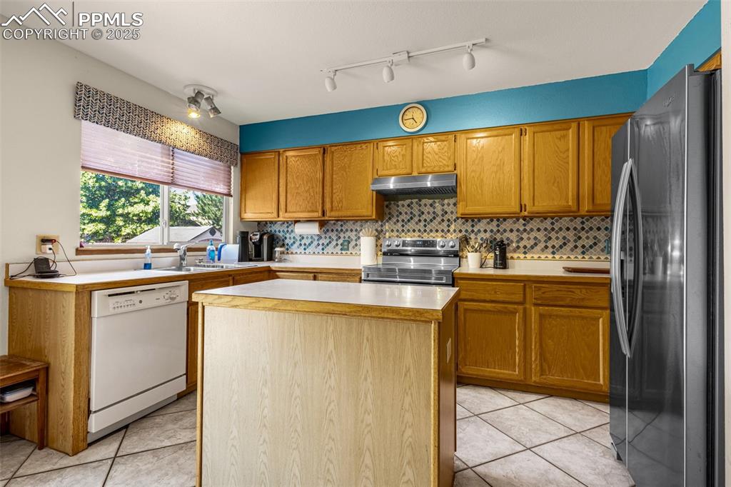 Image 8 of 33: Kitchen featuring appliances with stainless steel finishes, light counterto