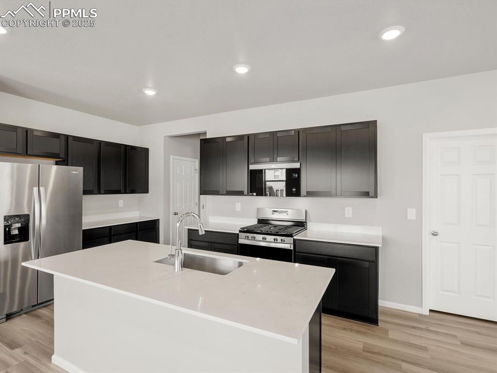 Image 3 of 15: Kitchen with stainless steel appliances, recessed lighting, light wood-styl