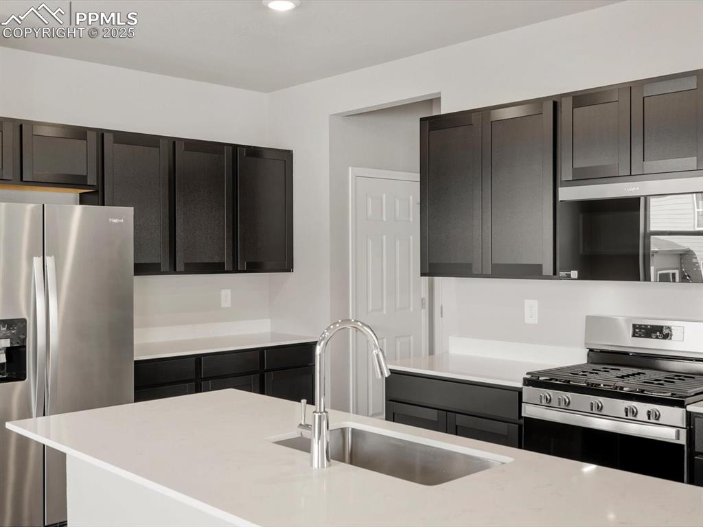 Image 4 of 15: Kitchen featuring stainless steel appliances, light stone counters, and rec