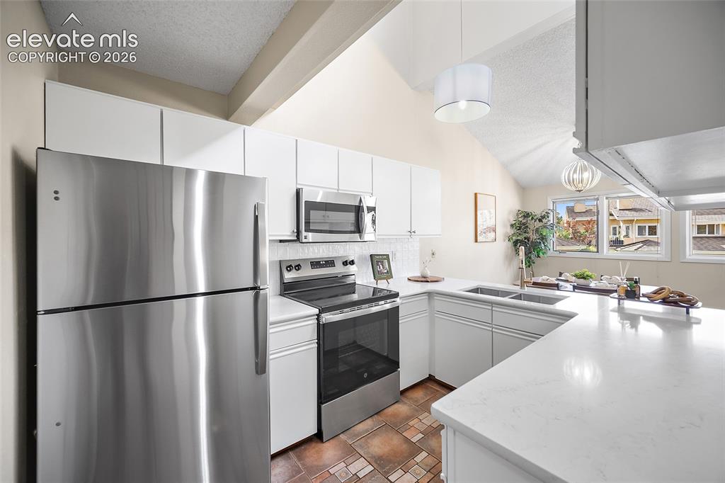 Image 13 of 42: Kitchen with stainless appliances and gorgeous quartz countertops