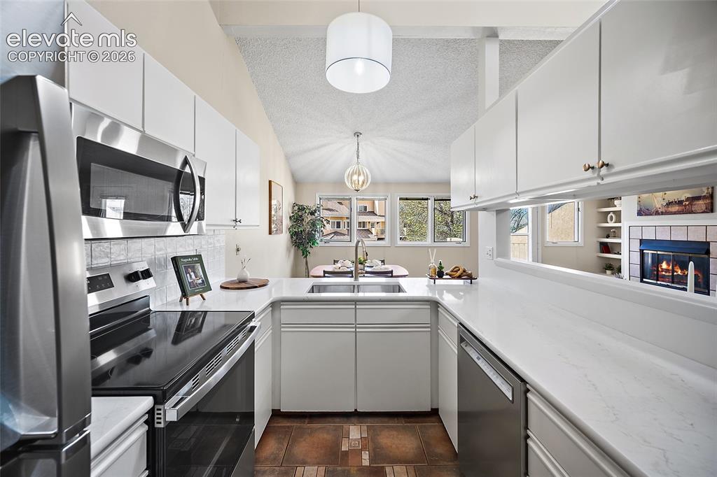 Image 14 of 42: Lovely light filled kitchen with ample quartz countertop space