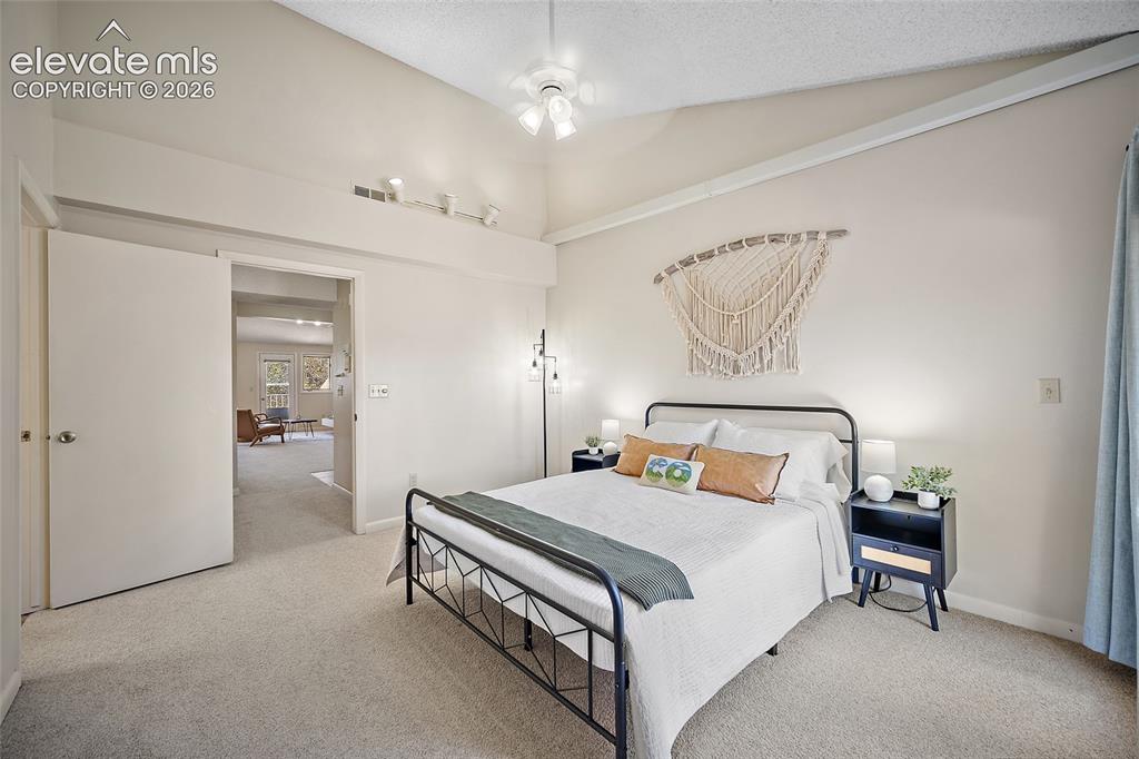 Image 19 of 42: Primary bedroom with vaulted ceiling