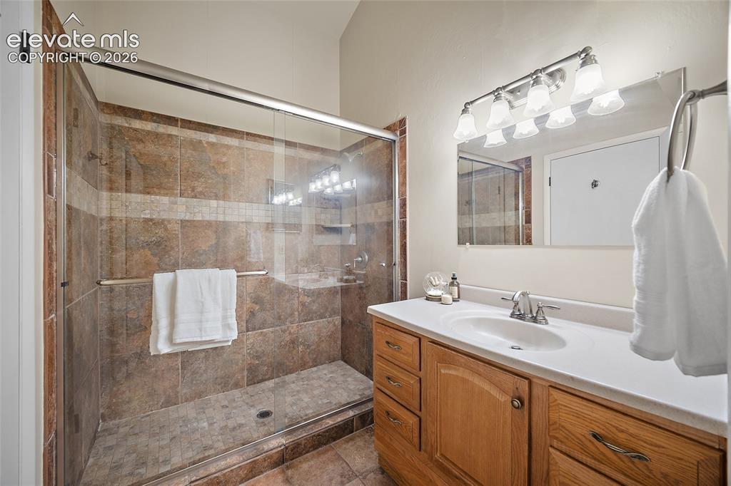 Image 21 of 42: Primary suite shower and vanity