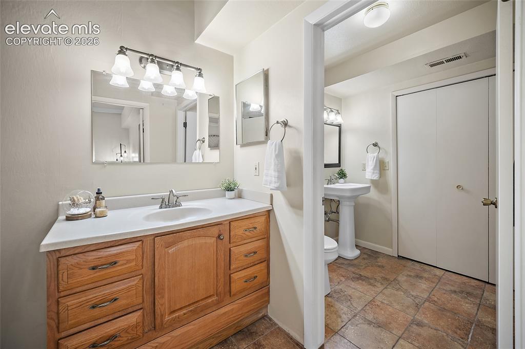 Image 22 of 42: Primary suite vanity leading to the separate standalone water closet with s