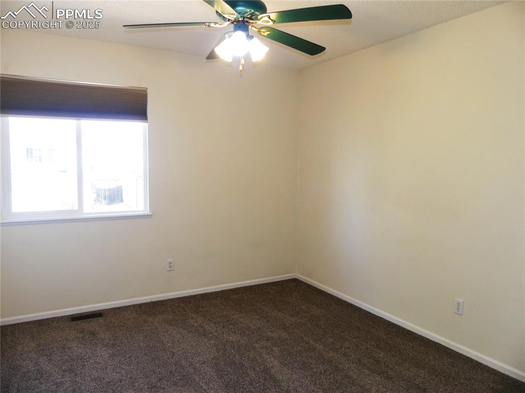 Image 35 of 42: Bedroom 2 with dark colored carpet, ceiling fan, and a textured ceiling