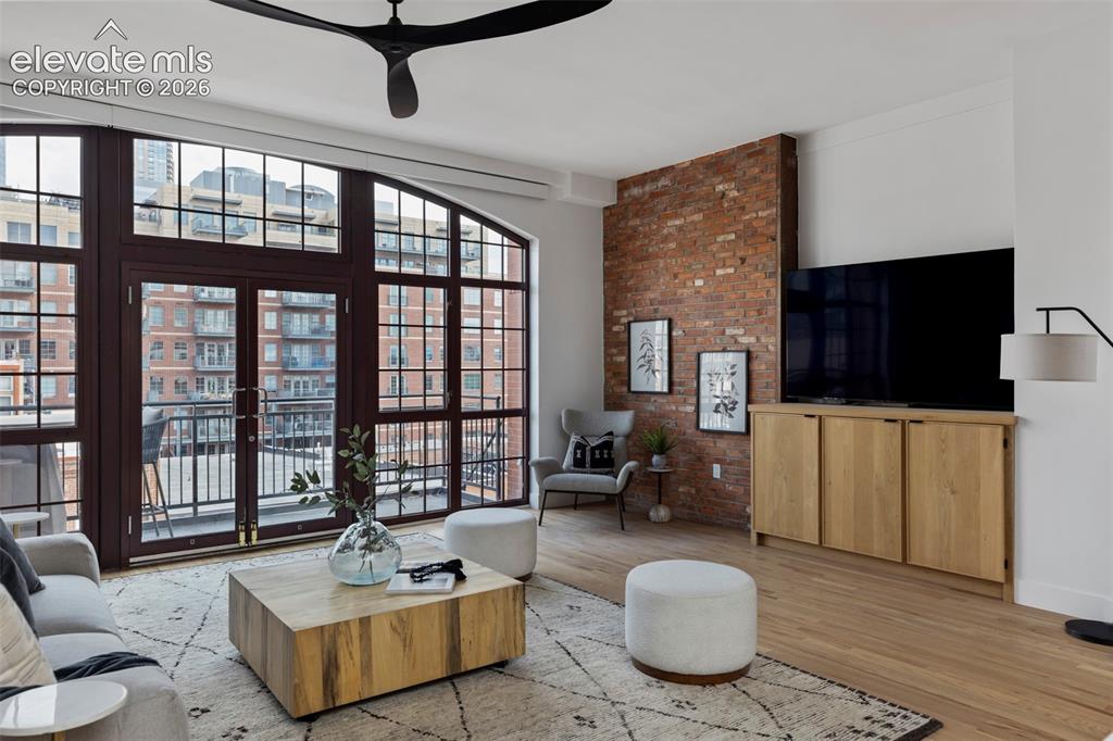 Image 10 of 33: Full-height arched windows with double doors, exposed brick accent wall, li