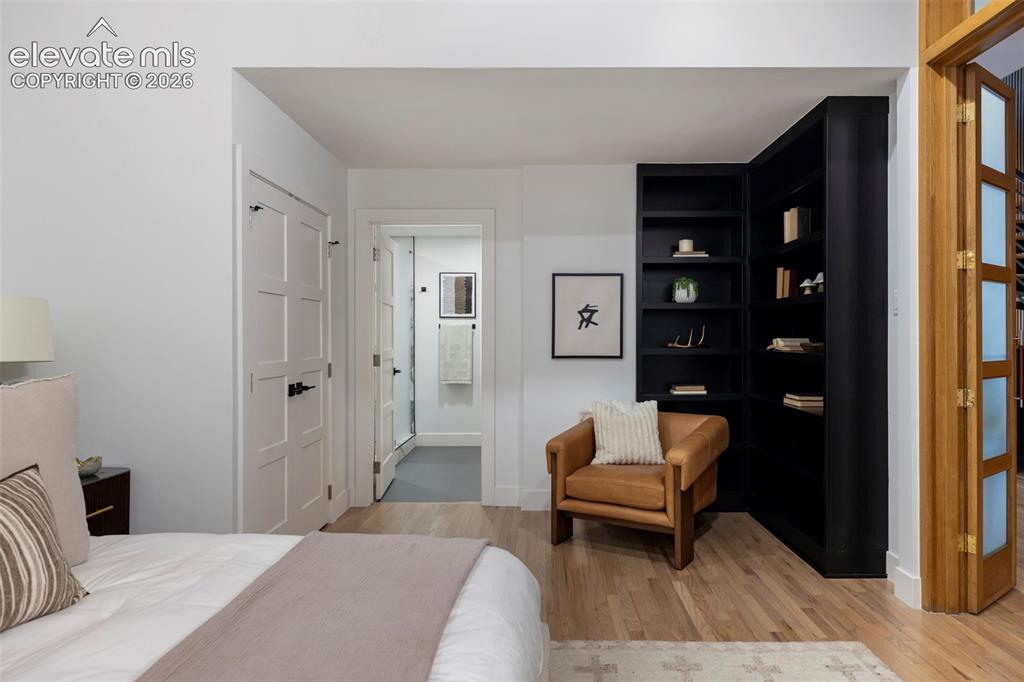 Image 15 of 33: Light-toned wood-finish flooring, built-in shelving in a dark finish, a pan
