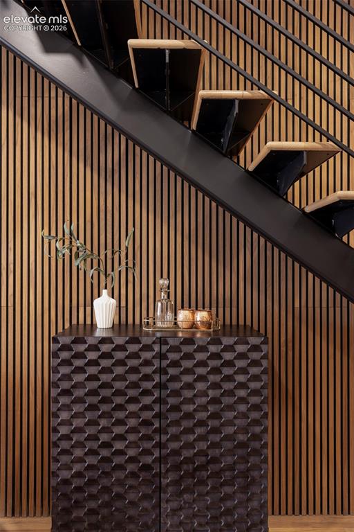 Image 17 of 33: Open-riser staircase with wood treads and a black metal railing