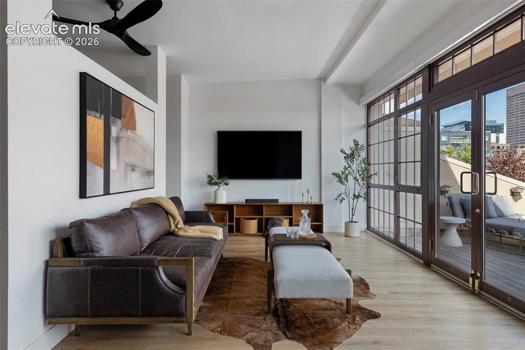 Image 19 of 33: Expansive living area with light wood-finish flooring, a contemporary ceili