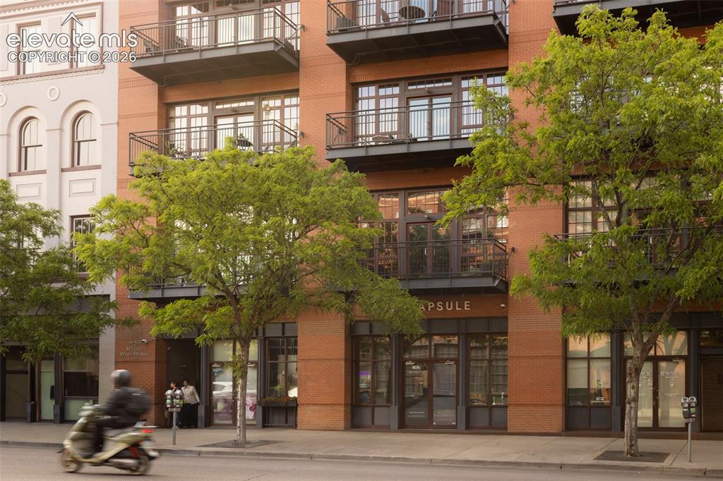 Image 2 of 33: Brick facade building featuring multiple private balconies with wrought iro