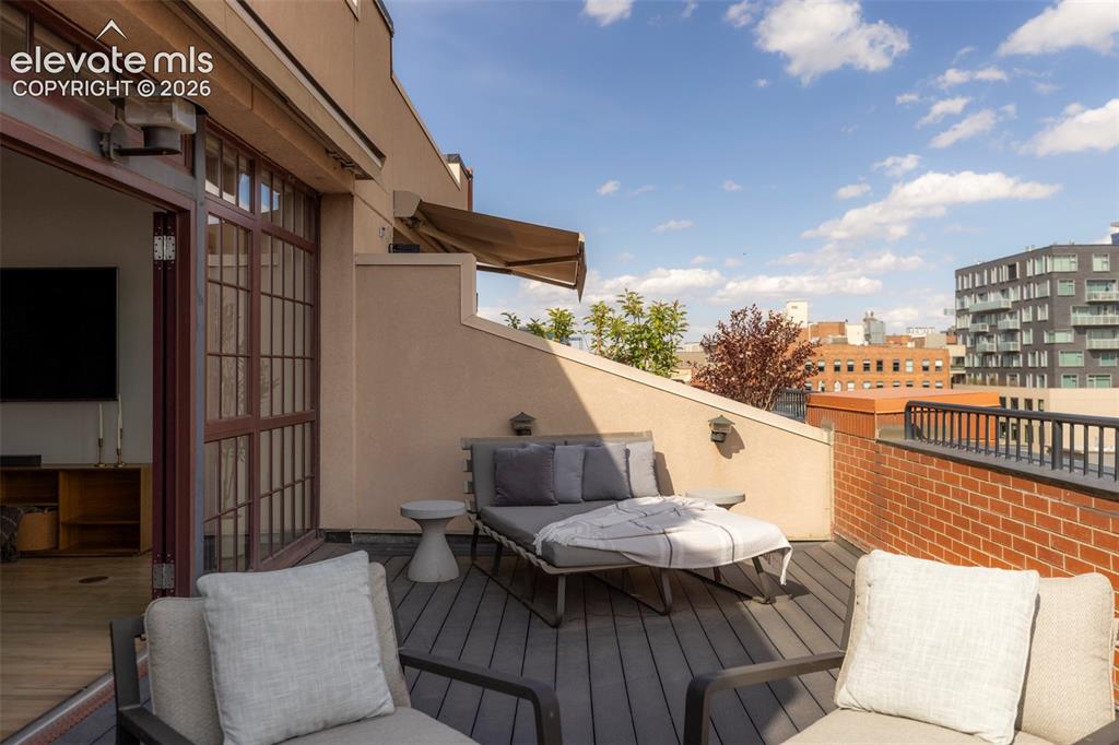 Image 21 of 33: Expansive outdoor deck featuring composite decking and a brick perimeter wa