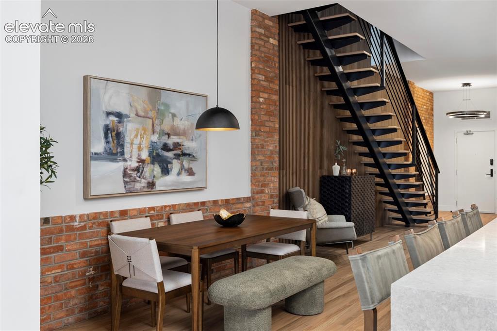 Image 7 of 33: Exposed brick wall detail, hardwood flooring, open riser staircase with met