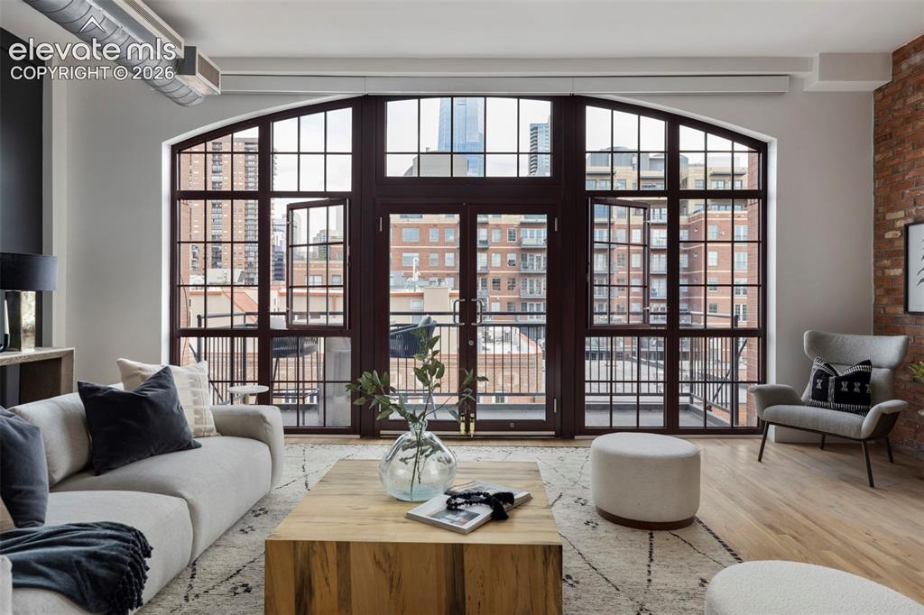 Image 9 of 33: Arched window wall with grid pattern, exposed brick accent wall, wood-finis