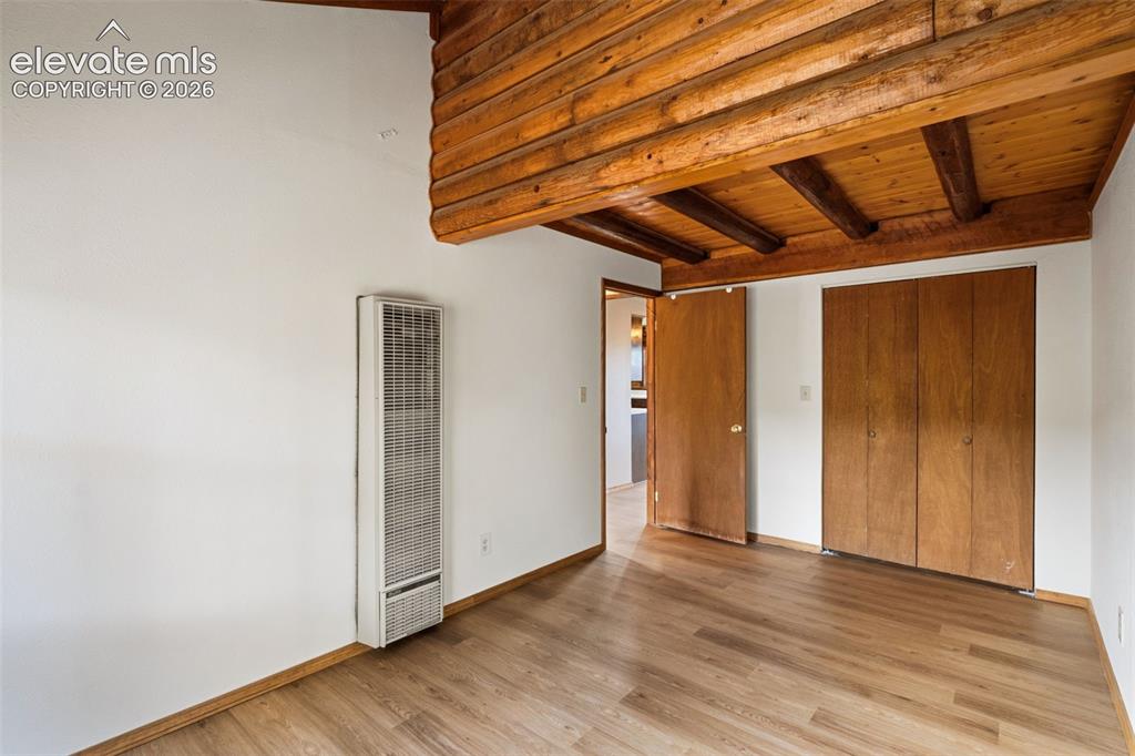 Image 11 of 32: Bedroom 2 combines new flooring with the character of natural log construct