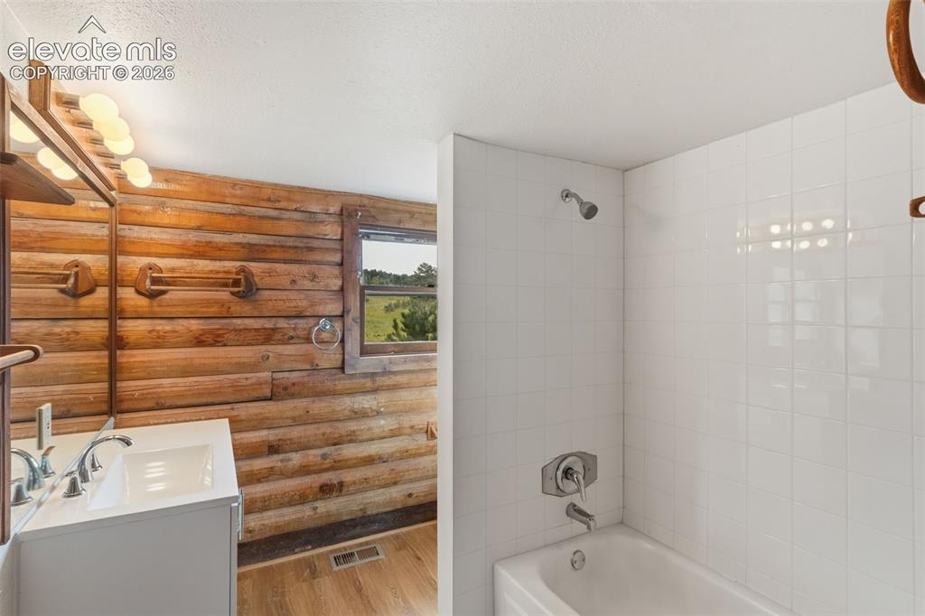 Image 14 of 32: Updated full bathroom conveniently located near both main level bedrooms.