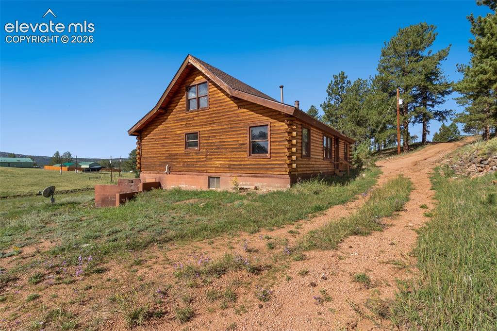 Image 32 of 32: Log home exterior surrounded by the Colorado mountain landscape.