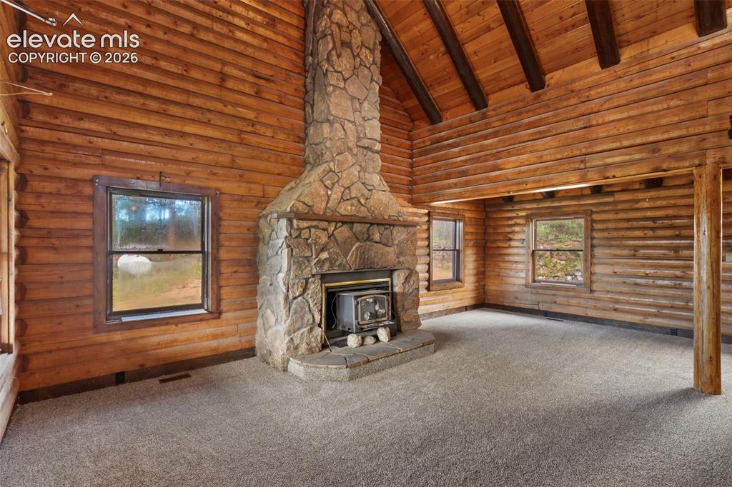 Image 4 of 32: Wood burning stove and stone surround create a natural focal point in the g