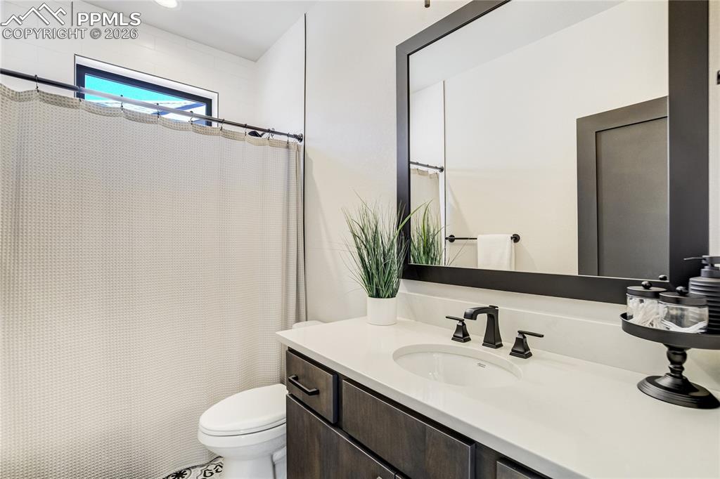 Image 23 of 50: Private ensuite for main level jr suite. Patterned tile and refined finishe