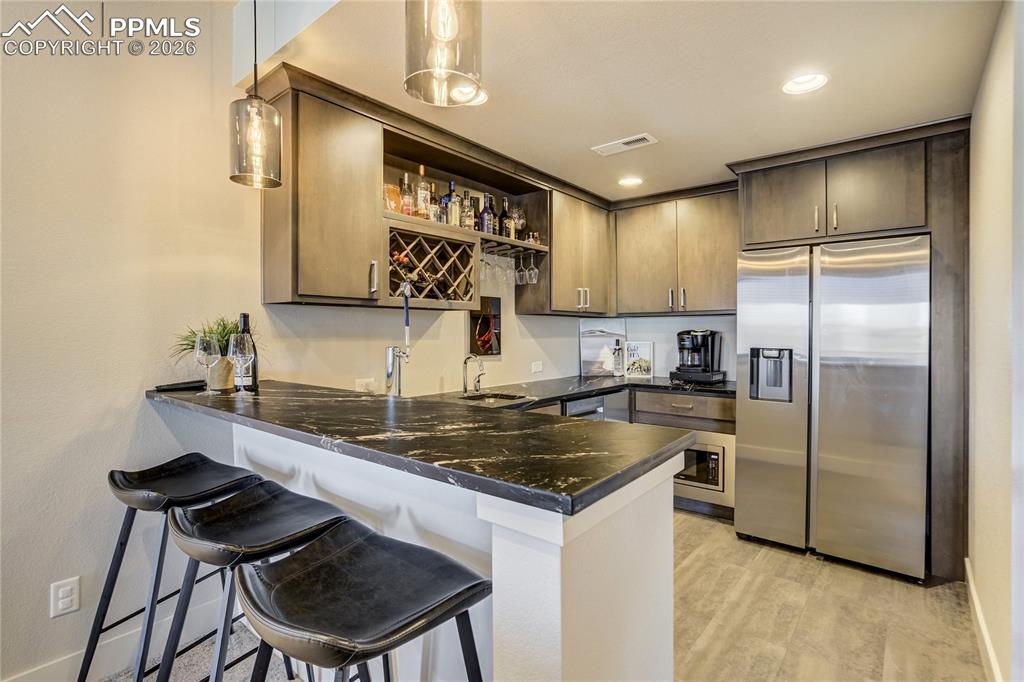 Image 30 of 50: Wet bar finished in Marine Black soapstone—rich, tactile and distinctive.  