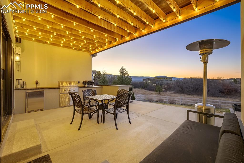 Image 39 of 50: Walk-out patio with integrated outdoor kitchen, extending the home’s entert