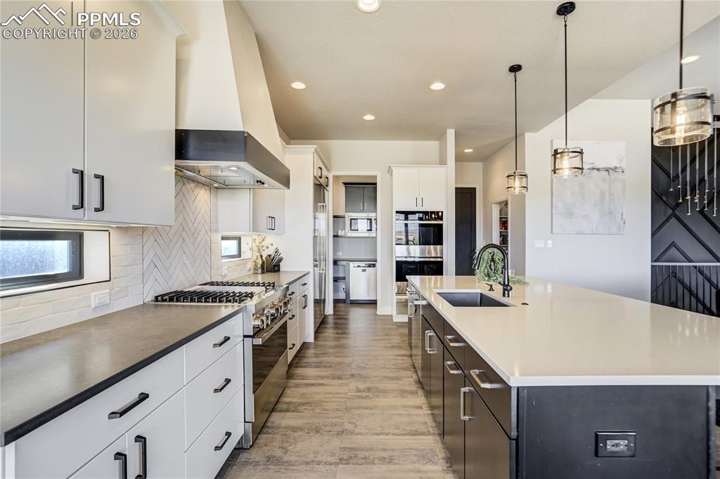 Image 8 of 50: White cabinetry and a contrasting island creating a modern, balanced palett