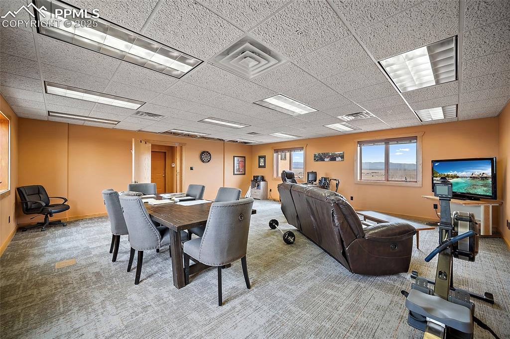 Image 10 of 31: Carpeted dining room with a drop ceiling and baseboards