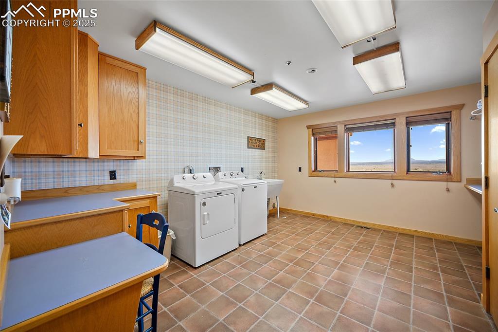 Image 11 of 31: Laundry room featuring light tile patterned floors and washing machine and