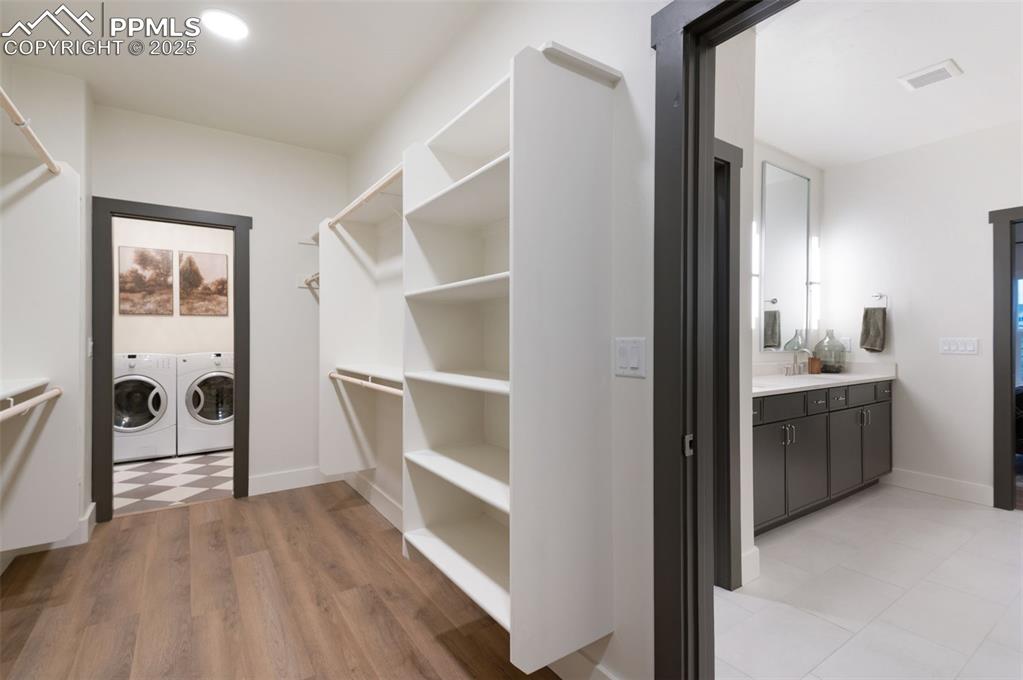 Image 21 of 42: Walk in closet featuring independent washer and dryer and light wood finish