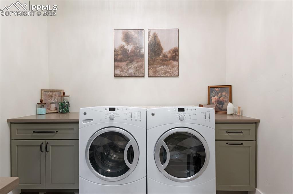 Image 22 of 42: Laundry room with cabinet space and washer and clothes dryer