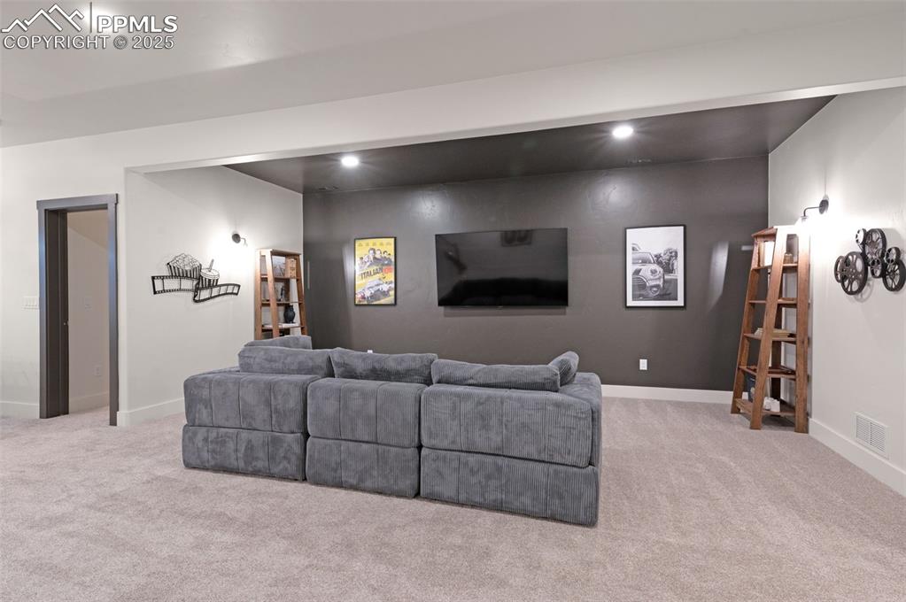Image 26 of 42: Living area with light colored carpet and recessed lighting