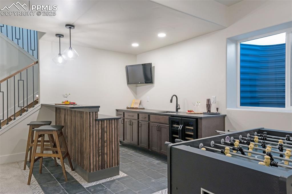 Image 29 of 42: Bar area featuring dark countertops, hanging light fixtures, recessed light