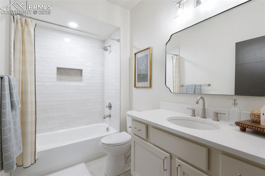 Image 36 of 42: Full bath with shower / tub combo, vanity, and light tile patterned floorin