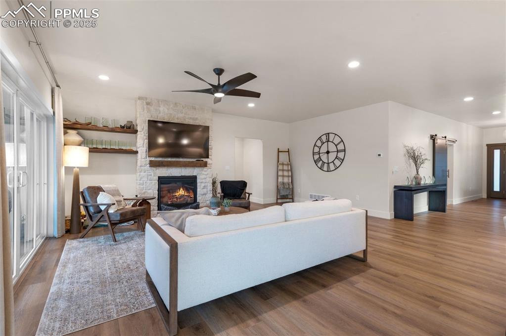 Image 5 of 42: Living area with recessed lighting, a fireplace, wood finished floors, and