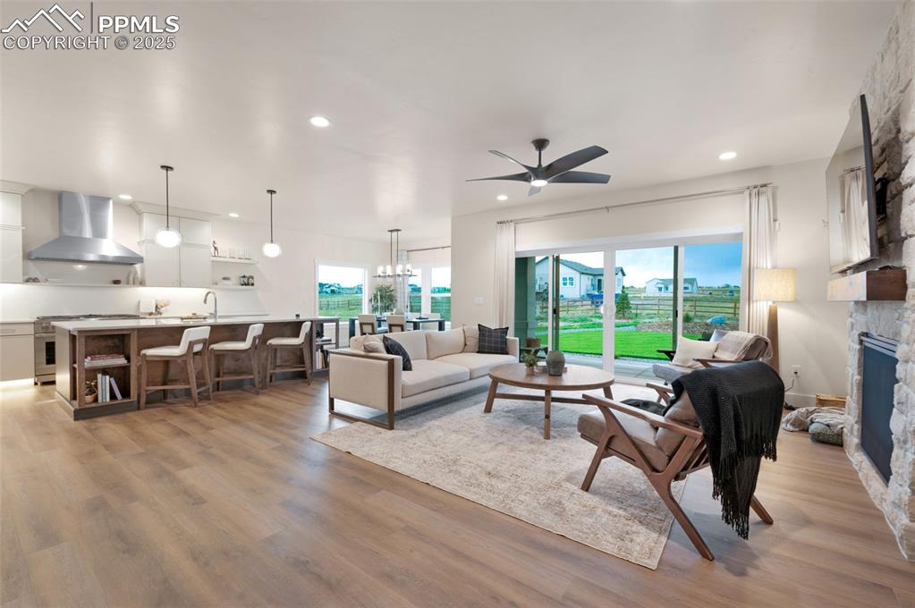 Image 7 of 42: Living room with light wood-type flooring, plenty of natural light, a firep