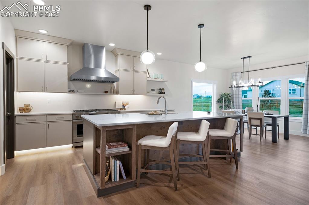 Image 8 of 42: Kitchen with open shelves, hanging light fixtures, wall chimney range hood,
