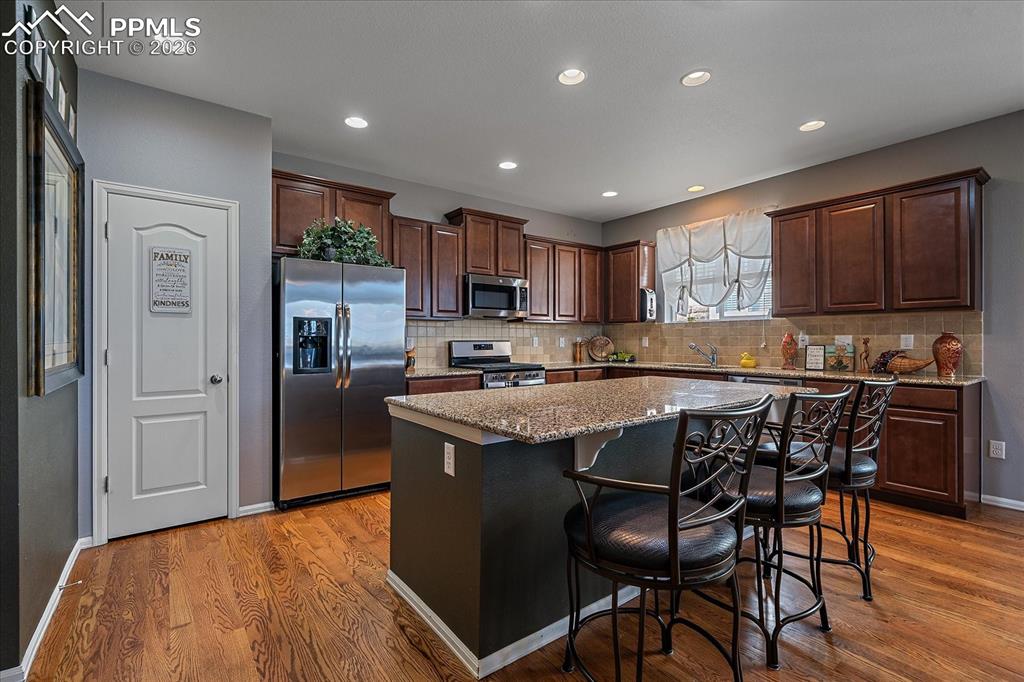 Image 10 of 47: Kitchen with appliances with stainless steel finishes, a kitchen island, li