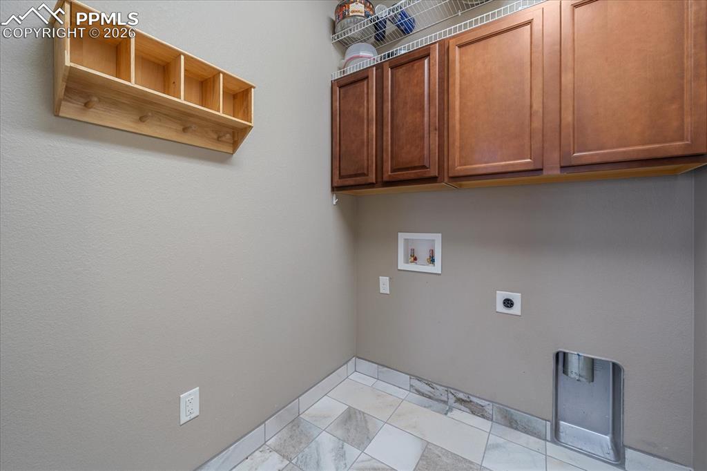 Image 15 of 47: Laundry room featuring washer and dryer hookups, and cabinet space