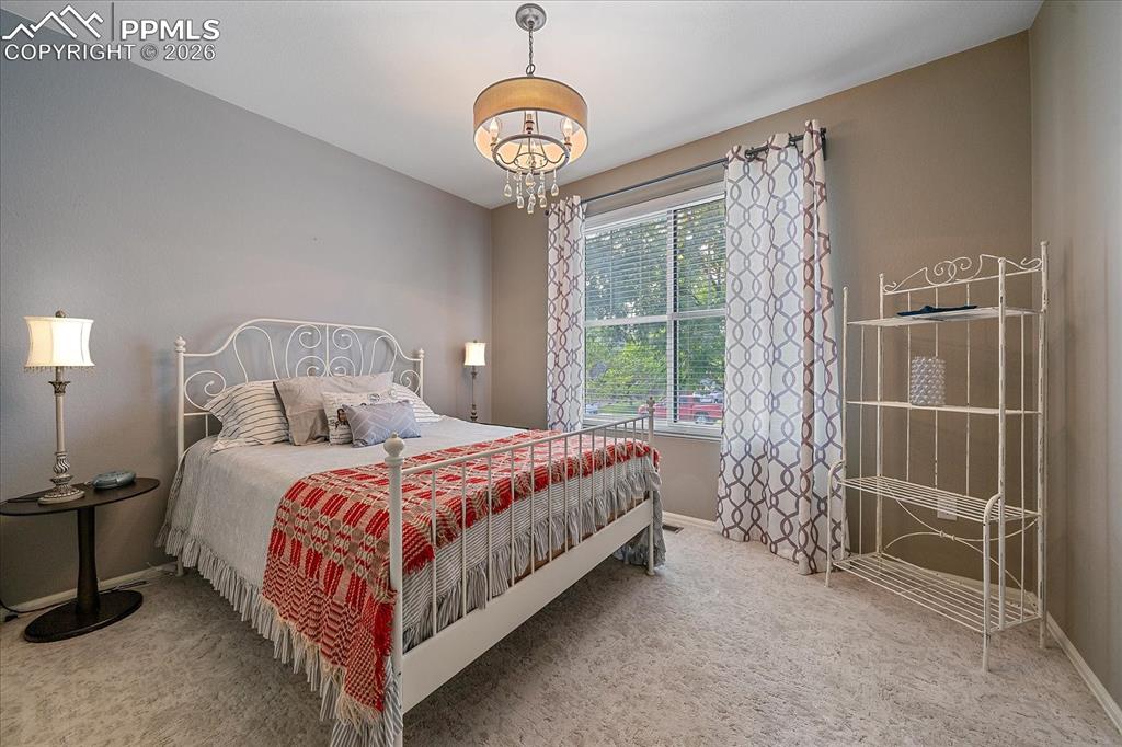 Image 21 of 47: Bedroom with carpet flooring and a chandelier