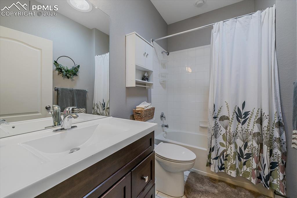 Image 22 of 47: Bathroom featuring shower / bath combination with curtain and vanity