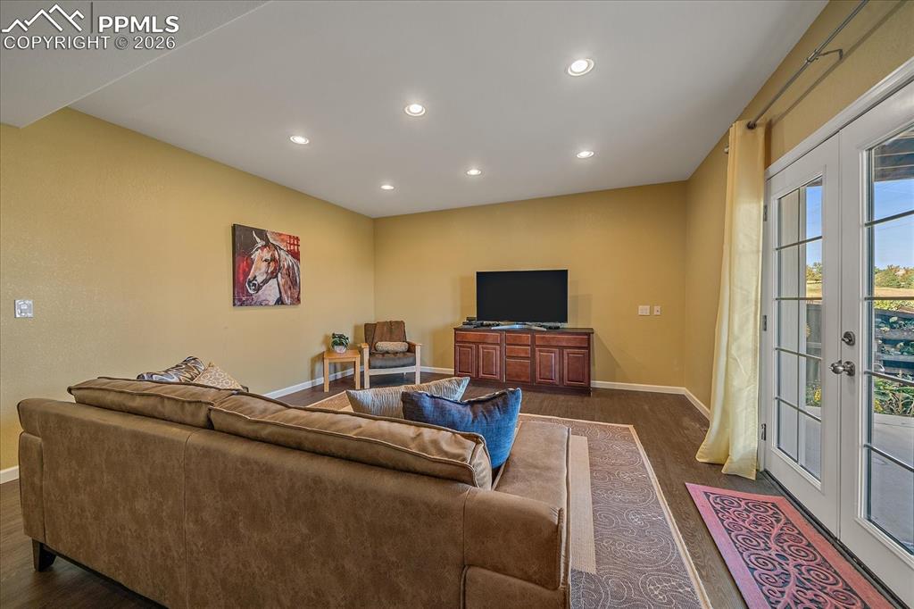 Image 25 of 47: Living room with recessed lighting, french doors, and dark wood-style floor