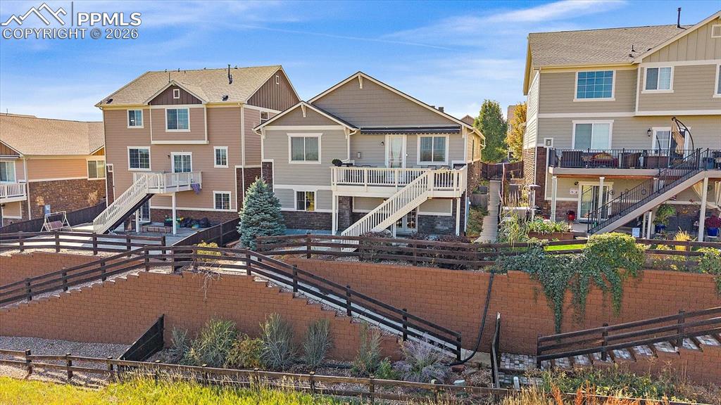 Image 40 of 47: Rear view of house featuring stairway, a residential view, a fenced backyar